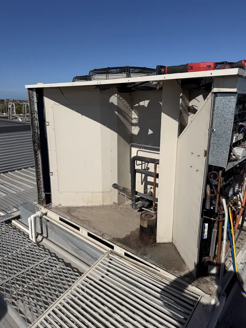 Commercial air-conditioning unit open for repair on a Perth rooftop