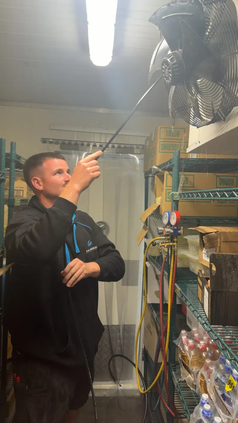 Calabreeze technician servicing a coolroom evaporator fan with gauges