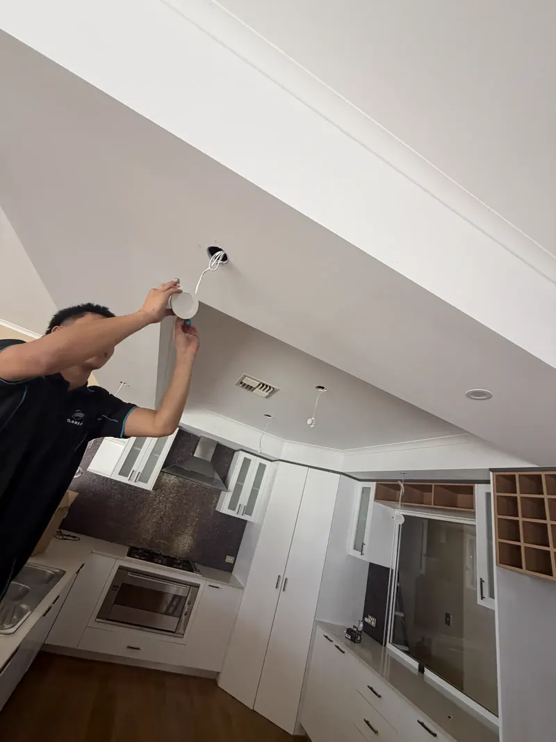 Calabreeze electrician installing an LED downlight in a Perth kitchen
